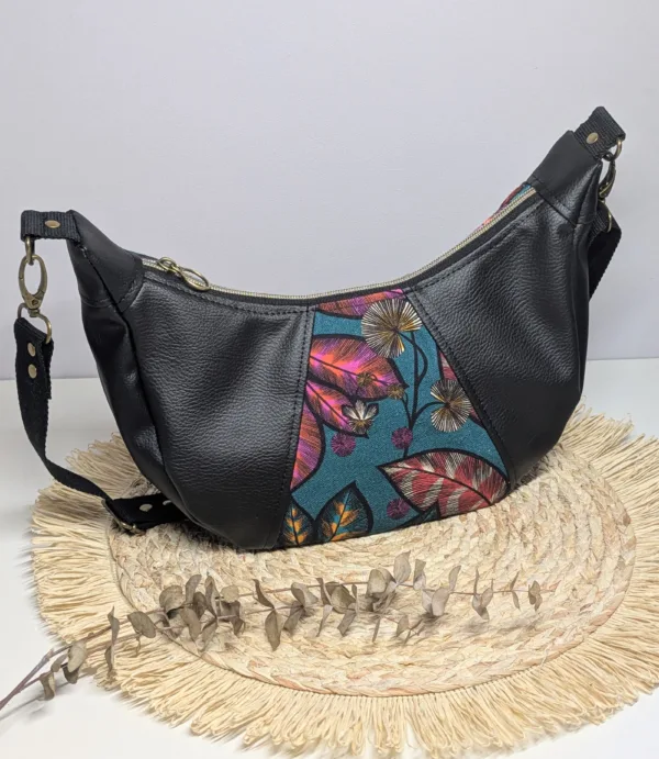Sac à main demi lune bi matière. Couleur tendance été. Pratique. Couleur noir et feuillage.