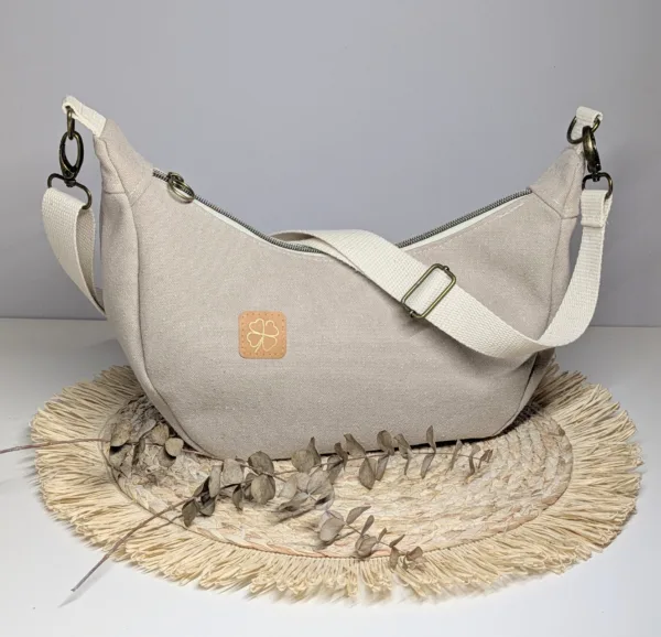 Sac à main demi lune toile beige. Couleur tendance été. Pratique.