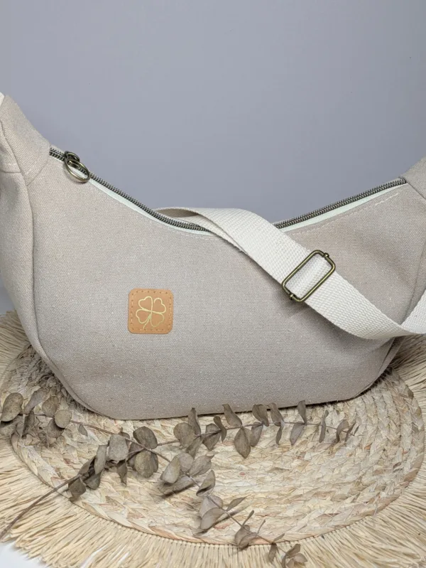 Sac à main demi lune toile beige. Couleur tendance été. Pratique.
